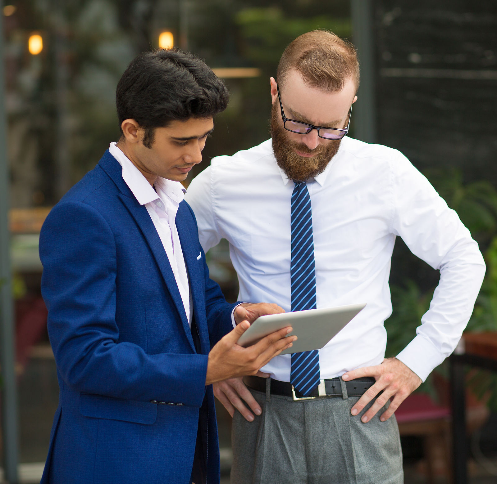 Two managers review data on a tablet, demonstrating digital skills development for workforce training.