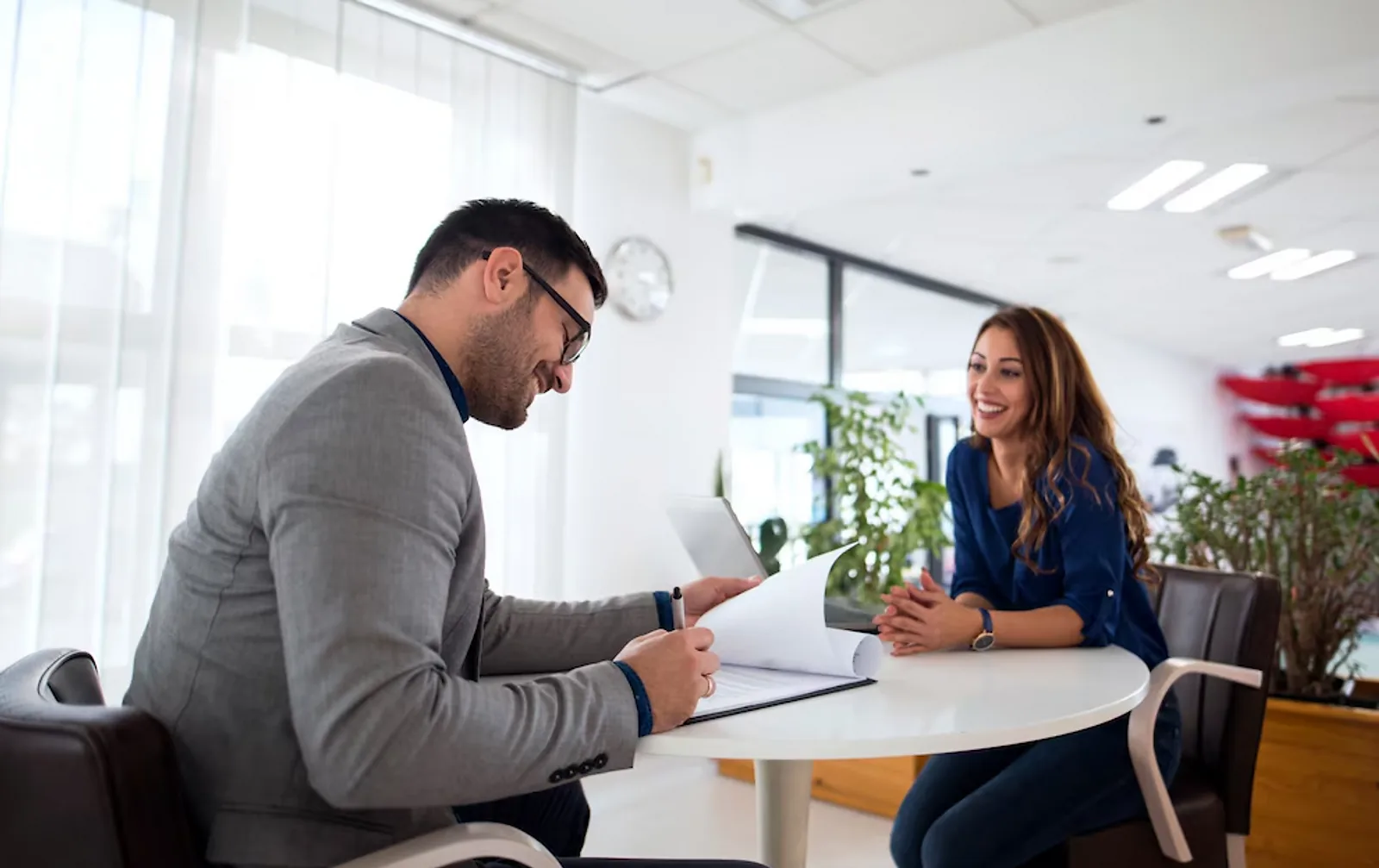 A man and woman discuss documents at a table, demonstrating important employability skills.