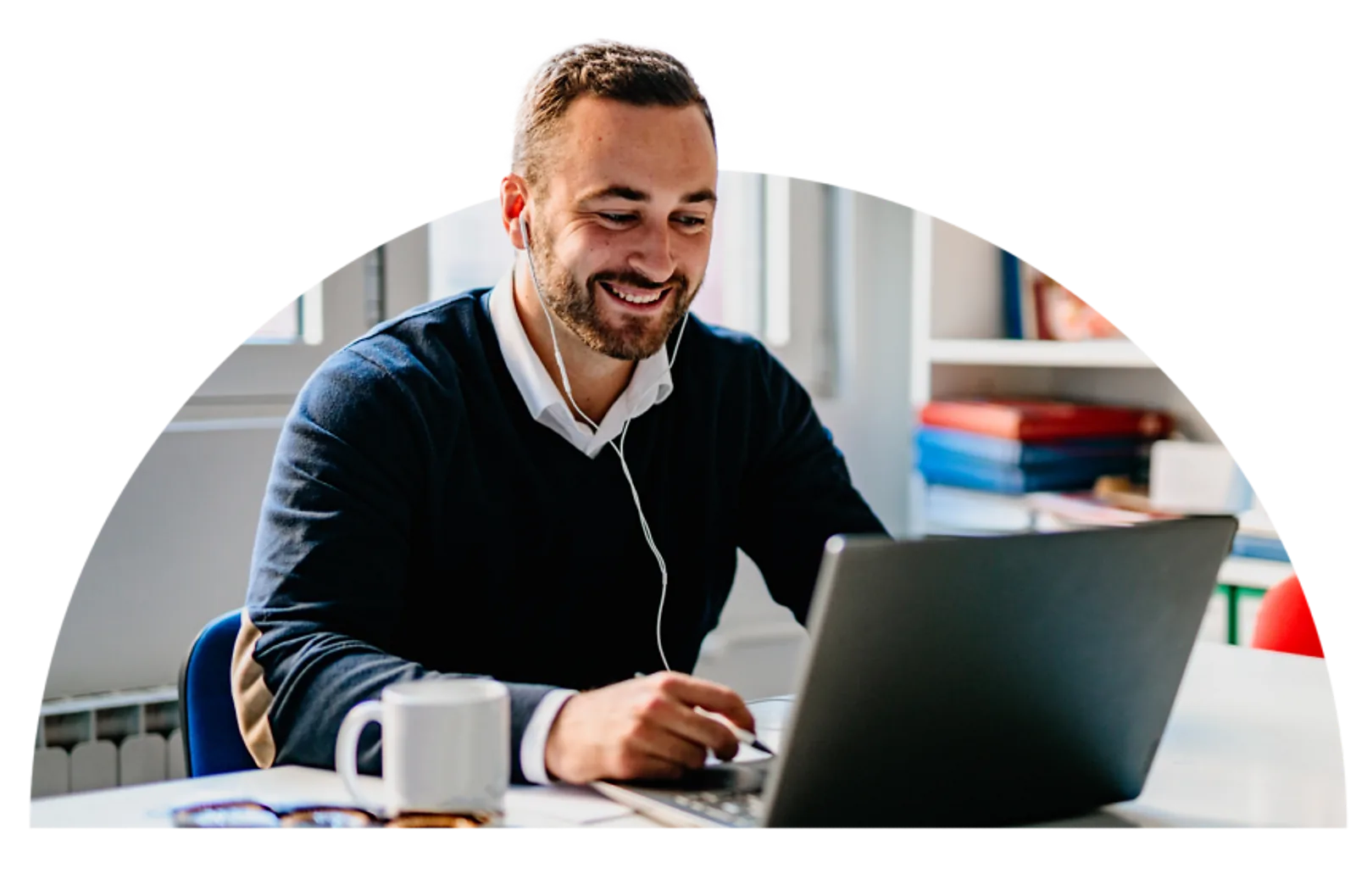 Man Using Laptop | CAQA LLND A smiling man works on a laptop with headphones, demonstrating digital skills training.