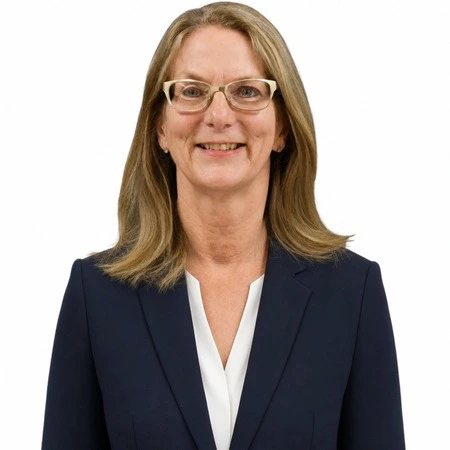 A professional woman with blonde hair smiles while wearing glasses and a dark suit, representing the CAQA LLND team.