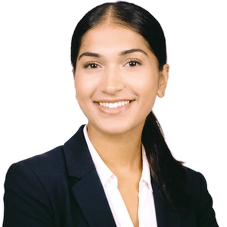 A smiling Avneet Bhinder poses in professional business attire as part of the CAQA LLND team.