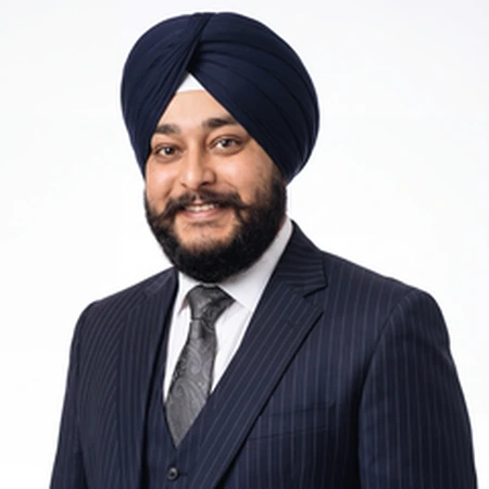 A smiling Chanpreet Singh, a business professional in formal wear, poses for a portrait.