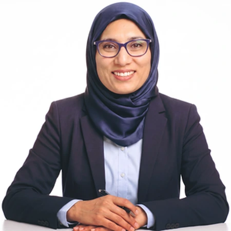 A professional Muslim woman, Jasmeet Chahal, smiles for a portrait on the CAQA LLND team page.