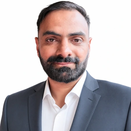Rukman Sangha is a business professional with dark hair and a beard.