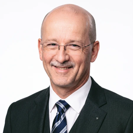 A smiling Steve Sutherland-Tomey, a business professional with glasses and mustache, as part of the CAQA LLND team.