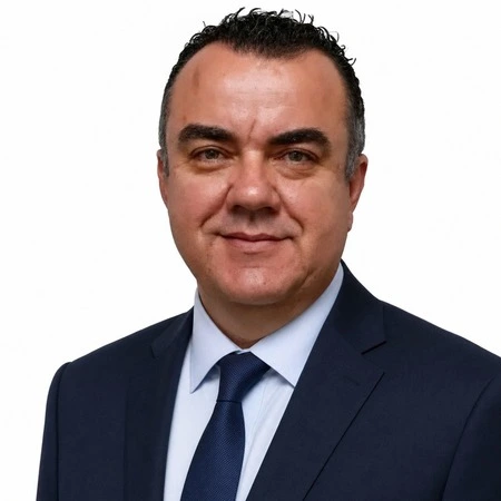 A professional man in a suit smiles at the camera as part of the CAQA LLND team.