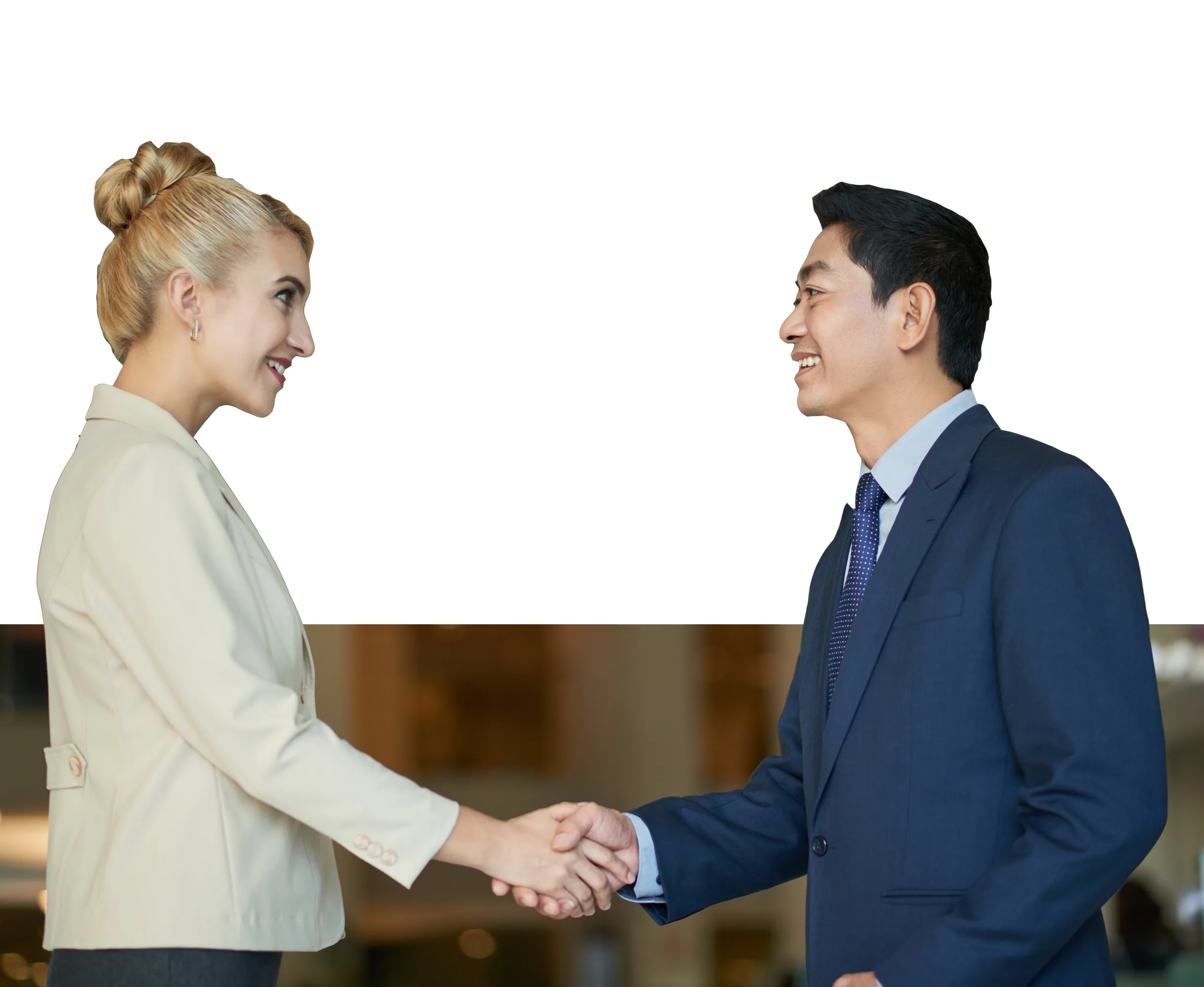 Two business professionals shake hands in an office, highlighting the importance of workplace communication skills.